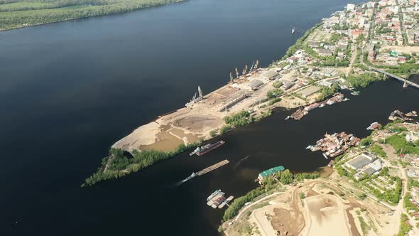 View From a Quadcopter To the Construction Port with Equipment and the City. Construction Barge