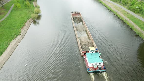 Aerial View of Large Cargo Barge Moving Along the River alt