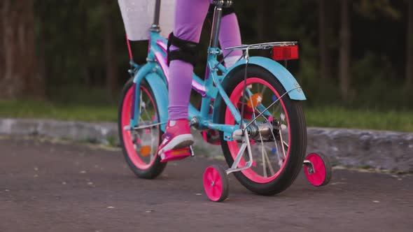 Little Girl Rides Bicycle in the Park