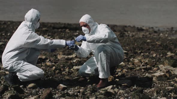 Forensic scientist examining sample at river bank