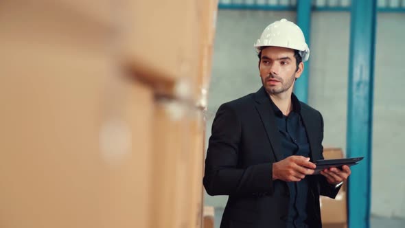 Factory Manager Using Tablet Computer in Warehouse or Factory alt