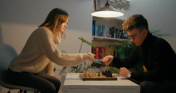 Young Couple Play Chess Game at Home
