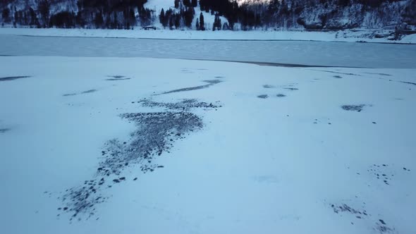 Icy Lake Surrounded by Snowy, Winter Landscape in Swiss Alps, Aerial alt