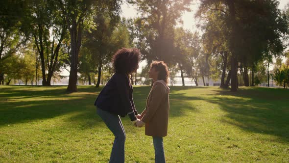 Family Touching Noses Holding Hands Together in Golden Sunlight Park Closeup alt
