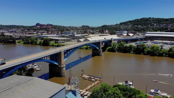 A high angle aerial slow reverse establishing shot of Pittsburgh's 31st Bridge spanning over the All alt