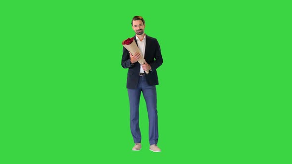 Smiling Handsome Businessman Holding Roses and Looking To Camera Flirting on a Green Screen Chroma alt
