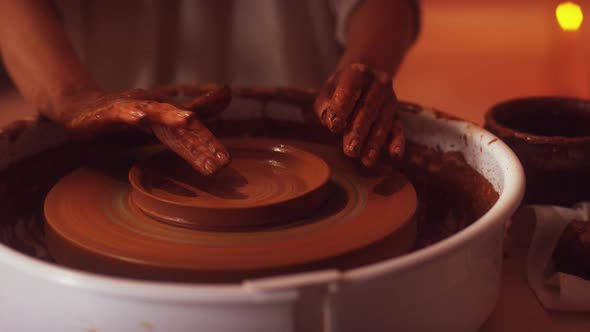 Women Hands are Working on Potter's Wheel Using Fingers for Shaping Clay Dish