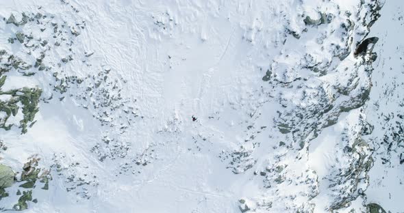Overhead Aerial Top View Over Winter Snowy Mountain with Mountaineering Skier People Walking Up