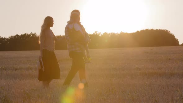 Holidays Weekend Outdoors in Nature Three Silhouettes Farmers on Background of Sunset Sky Sun Rays alt