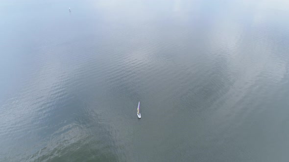 Aerial of windsurfer sailing on the water alt