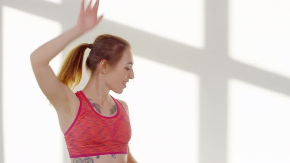 Young Woman in Sports Bra against White Background alt