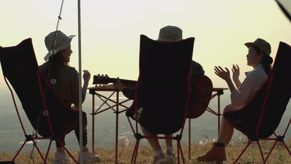 Group of Asian young women having fun and enjoy music form guitar.