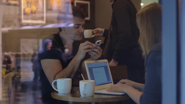 Man and woman work in the restaurant using gadgets alt