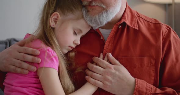 Close Up Portrait of a Father and His Daughter Who Sleeps in His Arms alt