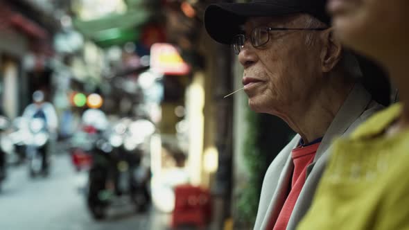 Handheld view of Vietnamese senior man in the street. Shot with RED helium camera in 8K alt