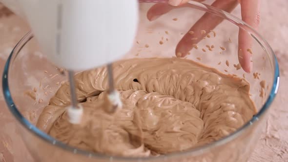 Mixing chocolate for cake with electric mixer.