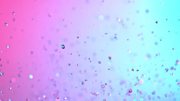 Super Slow Motion Shot of Flying Neon Water Drops at 1000Fps. alt