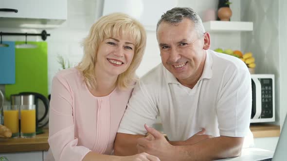 Happy Family Couple Posing for Photo in Modern Kitchen alt