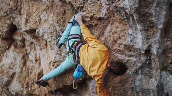 Skilful Athletic Male Rock Climber Climbs on Overhanging Rock Cliff alt