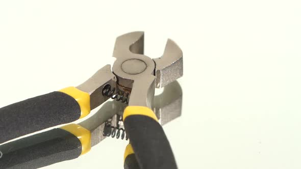 Part of Wire Cutters with Yellow, Gray Handle on White, Reflection, Rotation alt