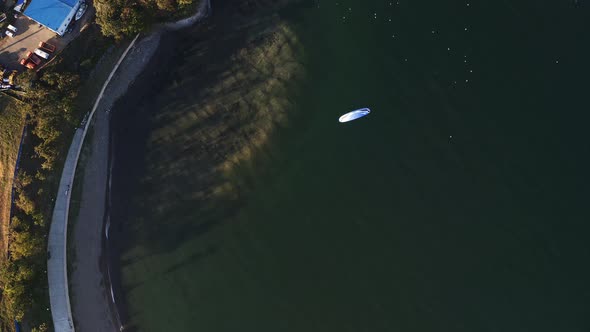 Aerial View of a Paraglider with an Engine Flying By the Coast of the Sea alt