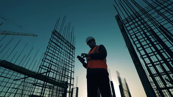 An Engineer Checks Construction Site with Reinforcement. alt