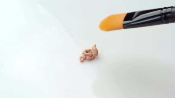 Facial Foundation Smudge Made with a Brush on White Makeup Palette Close Up alt