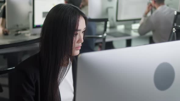 Attractive Young Woman Working on Decktop Computer While Working in Big Open Space Office alt