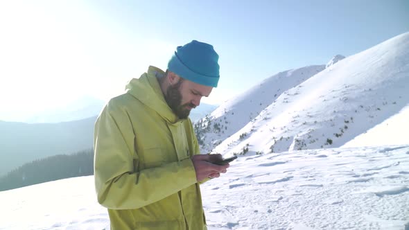 Stylish Bearded Hipster Texting a Message on His Smartphone