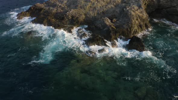 Sea waves crashing against rocks - Aerial drone view. Fly over water  alt
