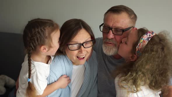 Grandpa and Grandma Laugh and Have Fun with Two Little Granddaughters. Happy Grandparents and Two alt