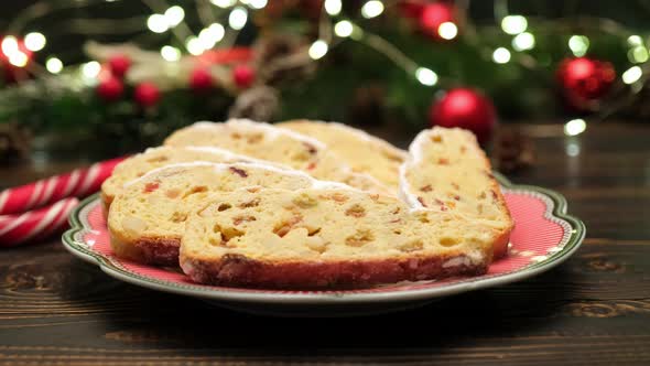 Sliced Traditional Christmas Stollen Cake with Marzipan and New Year Decorations on Wooden alt