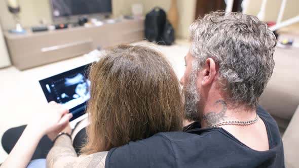 Ultrasound Echography of 4Th Month Fetus Seen By Future Parents on the Tablet alt