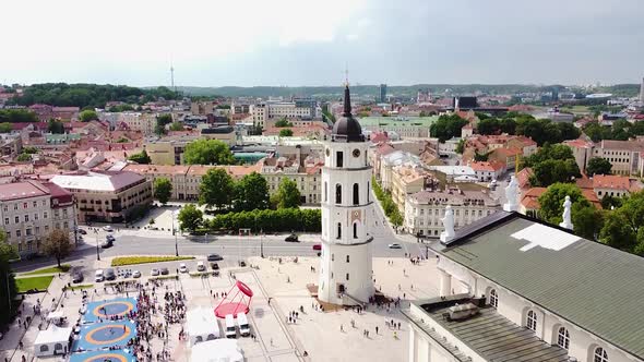 Vilnius Cathedral bell tower and majestic old town rooftops, aerial ascend alt