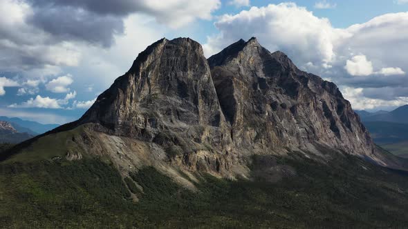 Flying Around Majestic Sukakpak Mountain against white clouds in summer Alaska alt