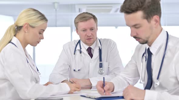 Professional Male Doctor Teaching Team on Paper in Office alt