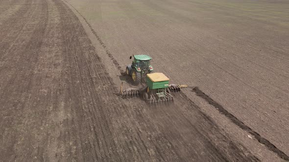 Tractor plows and cultivates the land for sowing alt