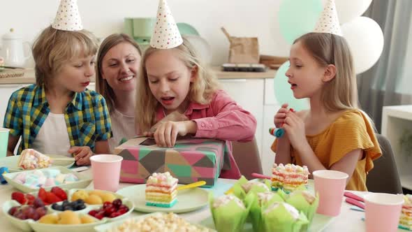 Girl Unwrapping Birthday Gift on Party alt