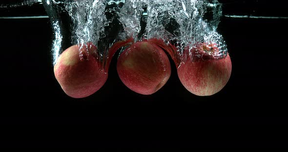 Apples, malus domestica, Fruits entering Water against Black Background, Slow Motion 4K alt