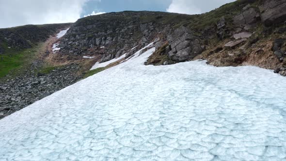 Aerial View Close-up Texture of a Snow Surface in the Mountains. Icy Blue Arctic Glacier. alt