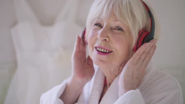 Closeup Face of Joyful Senior Woman with Grey Hair Singing Listening to Music in Headphones Looking alt