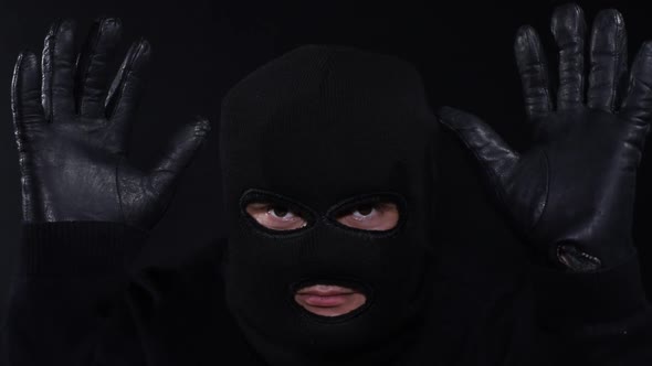 A criminal in a mask with a knife, a crazy maniac, touching his face with a knife in masks alt