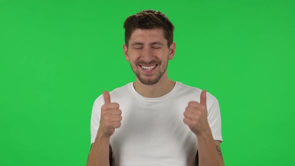 Portrait of Confident Guy Is Showing Thumbs Up, Gesture Like. Green Screen alt