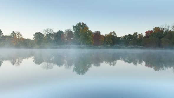 Aerial Morning Fog Above Still Lake Mist and Vibrant Orange Red Forest Trees alt