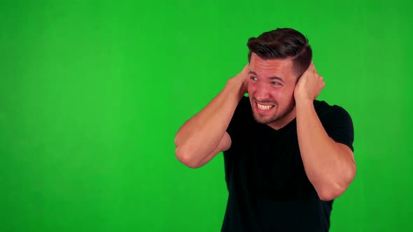 Young Handsome Caucasian Man Is Afraid (Man Covers His Ears) - Green Screen alt