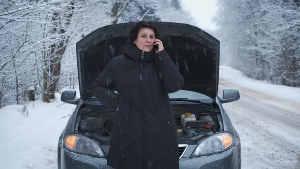 Woman in the Winter Forest Is Standing on the Road with a Broken Car