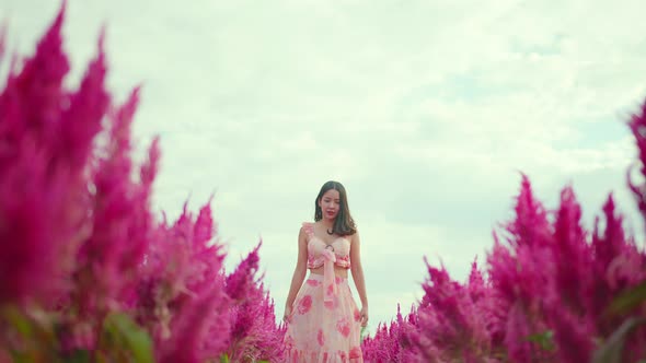 attractive asian female walking  along in beautiful flowers nature farm