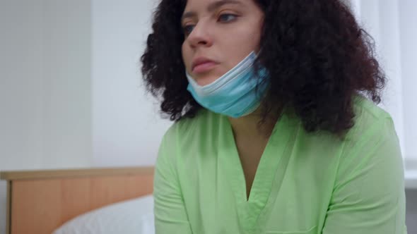 Portrait of Young Doctor Praying in Hospital Ward on Coronavirus Pandemic Outbreak alt