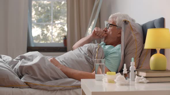 Retired Man Suffering From Cough and Cold in Bed at Home alt