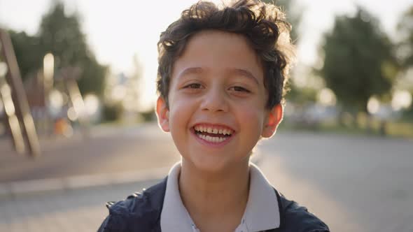 Adorable happy kid baby boy is looking to the camera. Baby looks around and then smiles and laughs.
